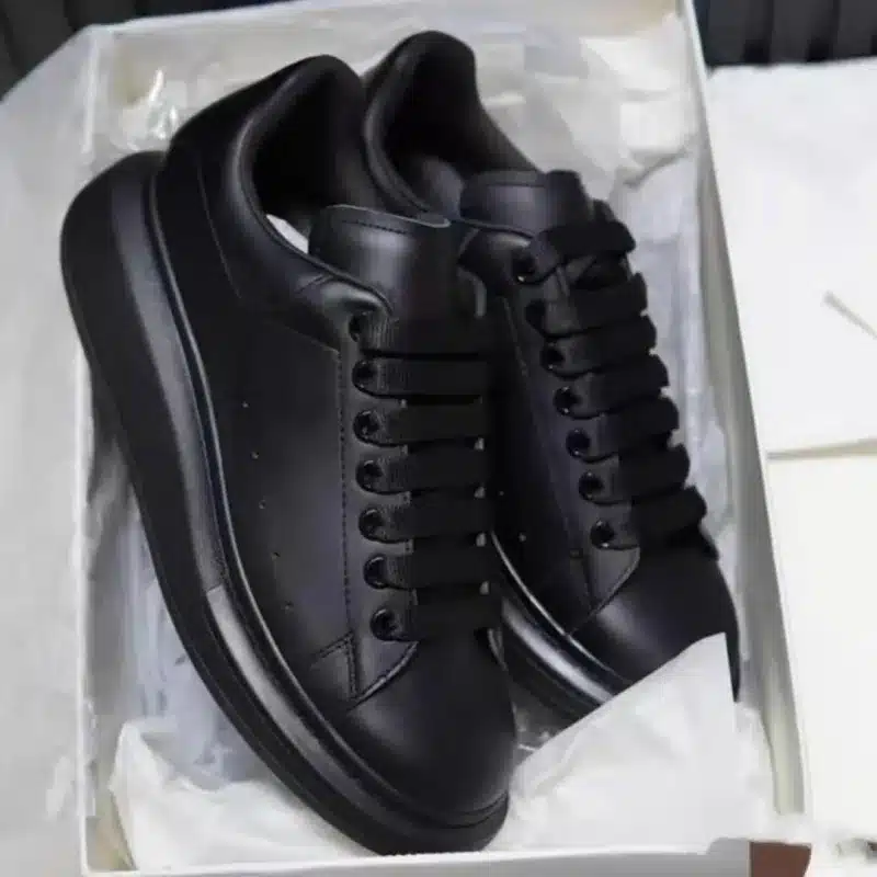 Black leather sneakers in a box, stylish casual footwear for men and women, Pryme brand.
